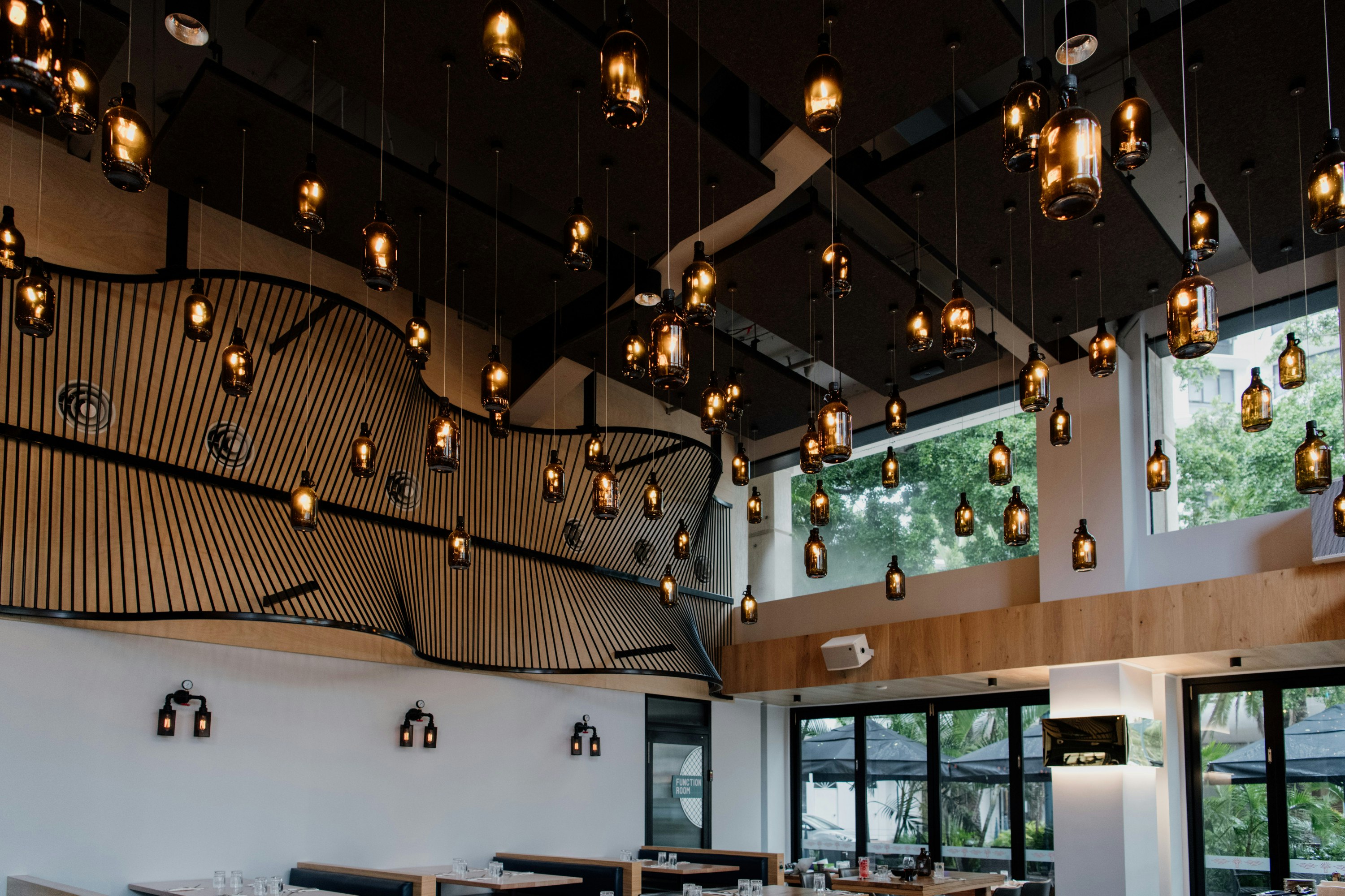 beer bottle lamps hanging from the ceiling of a brewpub